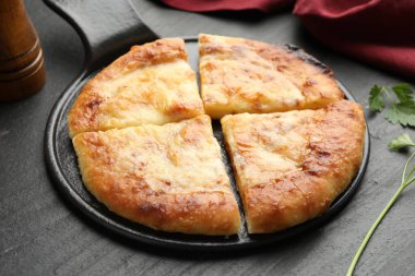 Megrelian khachapuri ve maydanozu siyah masaya yakın plan koyun.