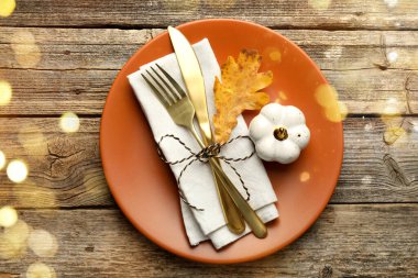 Sonbahar mekanı dekorasyonu, Bokeh ışıkları. Tabak, çatal bıçak ve sonbahar dekoru ahşap masa, üst manzara