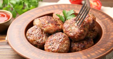 Ahşap masada çatalla kavrulmuş köfteyi yakın plan çekime alıyoruz.