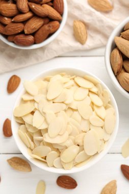 Taze badem gevrekleri ve beyaz ahşap masada fındıklar.