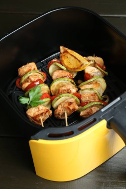 Kızarmış tavuk ve sebzeli şişler ahşap masada, yakın plan.