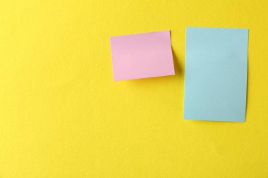 Sarı arka planda boş renkli notlar, üst manzara. Metin için boşluk