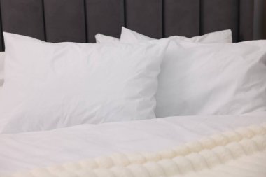 Temiz çarşafları olan büyük bir yatak, yakın plan.