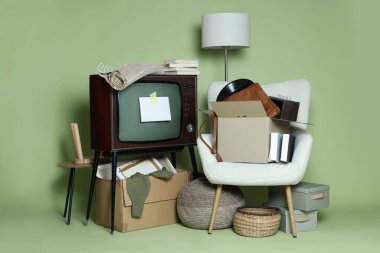 Garaj satışı. Yeşil arkaplanda boş kartı olan farklı kullanılmış eşyalar