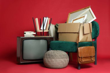 Garaj satışı. Kırmızı arkaplanda farklı kullanılmış şeyler