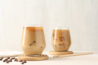 Sütlü buzlu kahve ve beyaz masada fasulye.