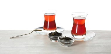 Geleneksel Türk çayı ve kuru yaprakları beyaz arka plana karşı ahşap masa üzerinde