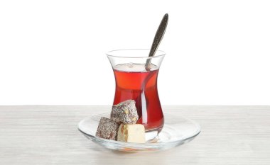 Geleneksel Türk çayı ve sevinci beyaz arka plana karşı ahşap masada