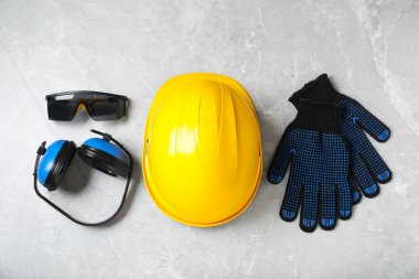 Açık gri mermer masada farklı güvenlik ekipmanları var.