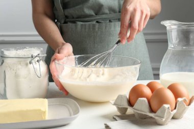 Beyaz masada hamuru hazırlayan kadın, yakın plan.