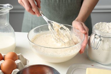 Beyaz masada hamuru hazırlayan kadın, yakın plan.