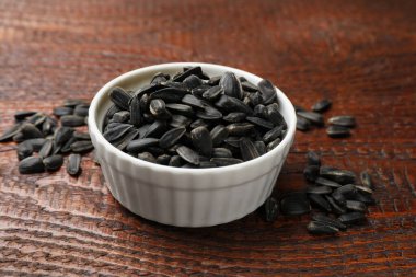 Tahta masadaki kasede ayçiçeği tohumları, yakın plan.