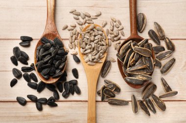 Kabuğu soyulmuş ve soyulmamış ayçiçeği tohumları beyaz ahşap masa üzerinde, düz uzanıyordu.