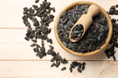 Ayçiçeği tohumları ve kepçeler beyaz ahşap masada, düz yatıyordu.