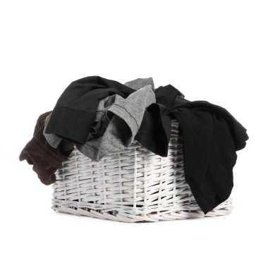 Wicker laundry basket full of clothes isolated on white