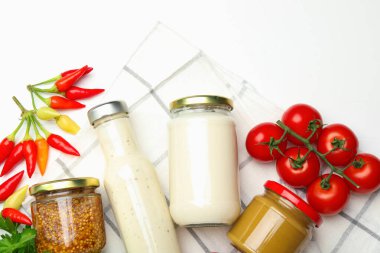 Farklı lezzetli soslar ve sebzeler ahşap masada, düz yerde.