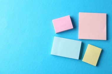 Açık mavi arkaplanda boş renkli notlar, düz yatış. Metin için boşluk