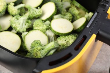 Çiğ brokoli ve kabağı gri masadaki tavada kes, yakın plan.