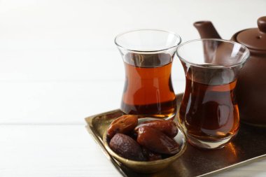 Geleneksel Türk çayı ve tarihler beyaz ahşap masada, yakın plan. Metin için boşluk