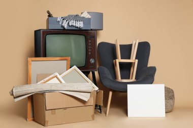 Garaj satışı. Bej arkaplanda boş kartı olan farklı kullanılmış eşyalar