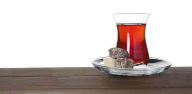 Geleneksel Türk çayı ve tatlısı beyaz arka plana karşı ahşap masada