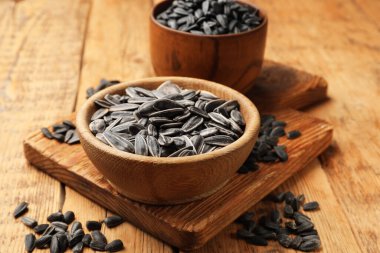 Ahşap masada soyulmamış ayçiçeği tohumları, yakın plan.