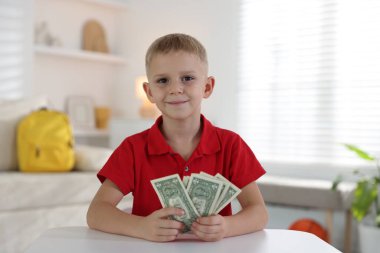 Beyaz masada cep harçlığı tutan küçük çocuk.