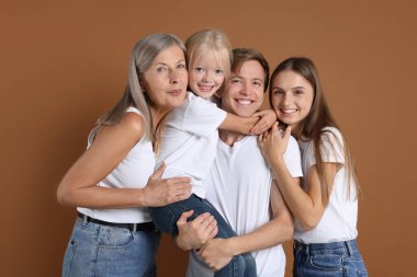 Kahverengi arka planda oğlu ve ailesi olan yaşlı bir kadının portresi.