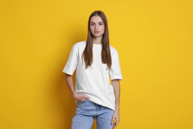 Turuncu arka planda beyaz tişört giyen bir kadın. Tasarım için model