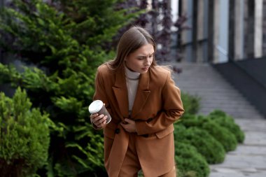 İçki içen genç bir kadın mide ağrısı ve mide bulantısı çekiyor.