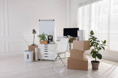 Taşınma günü. Mukavva kutular, bilgisayar ve mobilyalar ofiste.