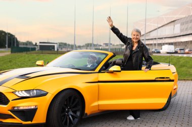 Modern Cabriolet 'ten çıkan şık bir kadın.