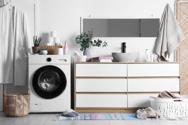 Çamaşır makinesi ve çamaşır sepeti banyoda lavabonun yanında. İç tasarım