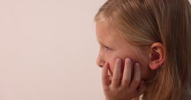 Üzgün küçük kız arka planda ağlıyor, yakın planda.