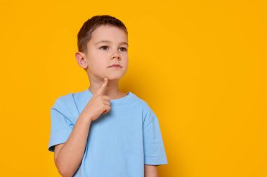 Turuncu arka planda küçük şirin bir çocuğun portresi.