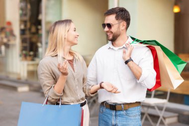 Farklı alışveriş çantaları olan mutlu bir çift.