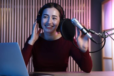 Podcast sunucusu stüdyoda talk show kaydediyor.