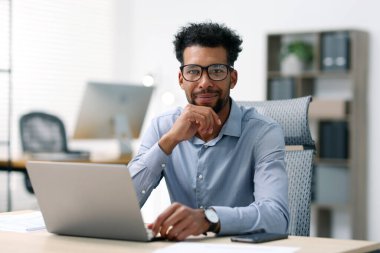 ofiste masada dizüstü bilgisayarda çalışan adam