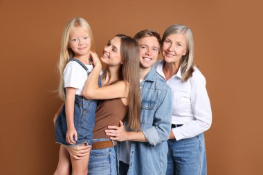 Kahverengi arka planda oğlu ve ailesi olan yaşlı bir kadının portresi.