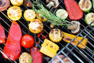 Vejetaryen barbeküsü. Izgarada farklı pişirilmiş sebzeler, yakın plan