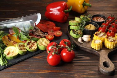 Vejetaryen barbeküsü. Ahşap masada servis edilen lezzetli ızgara sebzeler, yakın plan.