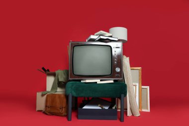 Garaj satışı. Kırmızı arkaplanda farklı kullanılmış şeyler