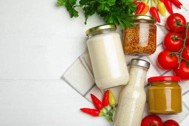 Farklı lezzetli soslar ve sebzeler ahşap masada, düz yerde. Metin için boşluk