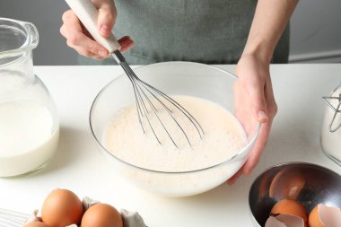 Beyaz masada hamuru hazırlayan kadın, yakın plan.