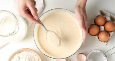 Beyaz masada hamuru yapan kadın (sıvı hamur), üst görünüm