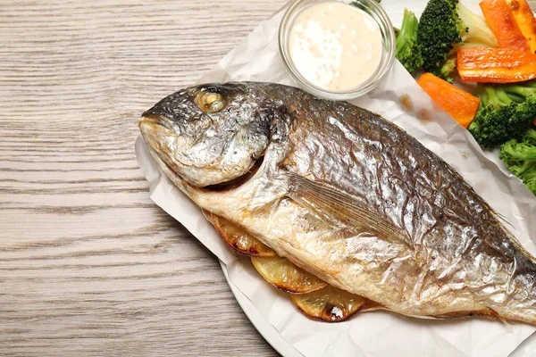 Lezzetli ızgara balık, sebze ve sos ahşap masa, üst manzara. Metin için boşluk