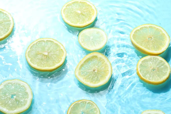 Açık mavi arkaplanda limon dilimleri, yakın plan.