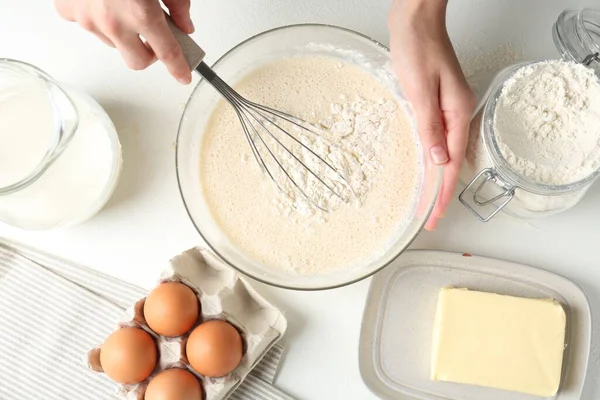 Beyaz masada hamuru yapan kadın (sıvı hamur), üst görünüm