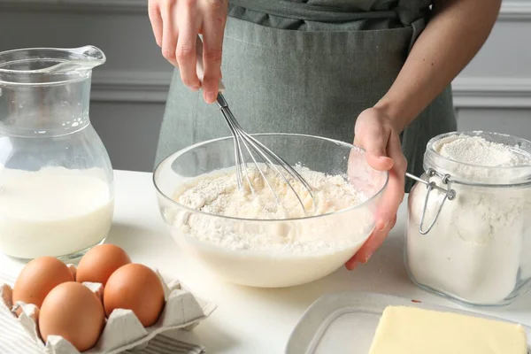 Beyaz masada hamuru hazırlayan kadın, yakın plan.