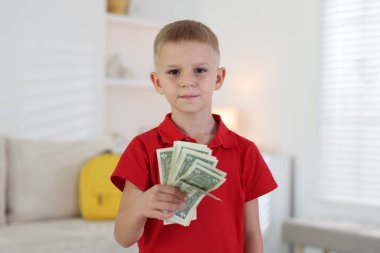 Evde cep harçlığı tutan küçük çocuk.